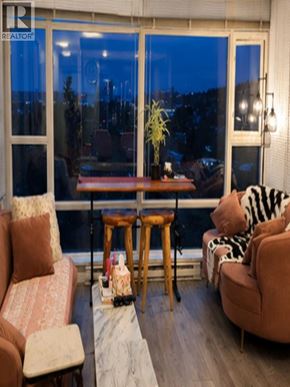 Coquitlam apartment for rent - A living room with a brown couch, a wooden table, and a zebra print pillow.