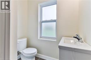 Brantford apartment for rent - A white toilet sits next to a sink in a bathroom.