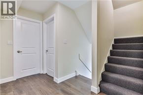 Brantford apartment for rent - A staircase with a carpeted runner leads up to a landing with two white doors.