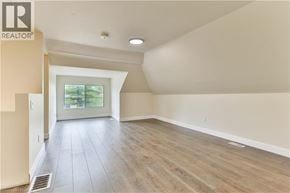 Brantford apartment for rent - A spacious room with wooden flooring and a sliding glass door leading to a garden.