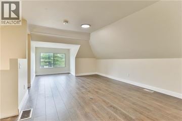 Brantford apartment for rent - A spacious room with wooden flooring and a sliding glass door leading to a garden.