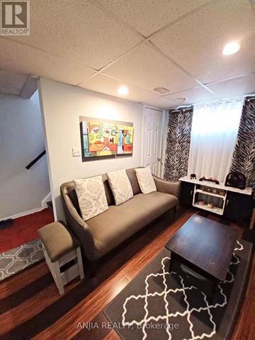 Toronto (Newtonbrook West) apartment for rent - A living room with a couch, a chair, and a painting on the wall.