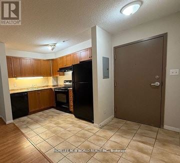 Toronto (Agincourt North) condo for rent - A kitchen with black appliances and wooden cabinets.
