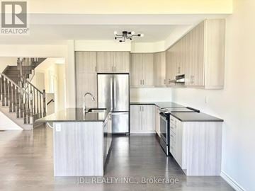 Vaughan (Kleinburg) apartment for rent - A modern kitchen with stainless steel appliances and white cabinets.