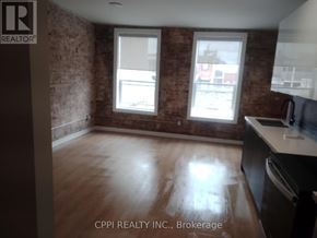 Peterborough (Town Ward 3) condo for rent - A room with a brick wall and wooden flooring is on the market with CPI Realty INC.