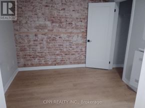 Peterborough (Town Ward 3) condo for rent - A room with a brick wall and a white door.
