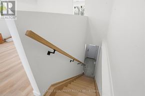 Toronto (Yorkdale-Glen Park) apartment for rent - A staircase with a wooden handrail and a metal box underneath it.