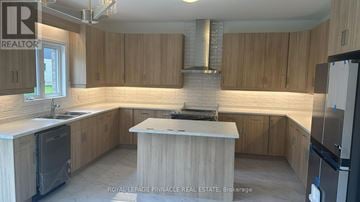 Pelham (Fonthill) apartment for rent - A kitchen with wooden cabinets and a central island.