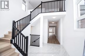 Pelham (Fonthill) apartment for rent - A white interior with a black railing staircase.