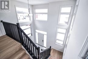 Pelham (Fonthill) apartment for rent - A white room with a black railing and wooden floors.