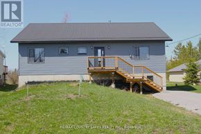 Kawartha Lakes (Carden) apartment for rent - A house with a grey roof and a wooden deck.