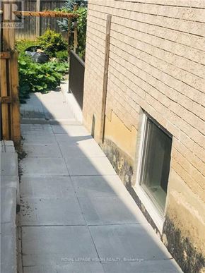 Whitby (Rolling Acres) apartment for rent - A concrete walkway leads to a door with a window on the side of a building.
