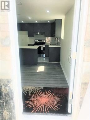 Whitby (Rolling Acres) apartment for rent - A modern kitchen with black cabinets and a wooden floor.
