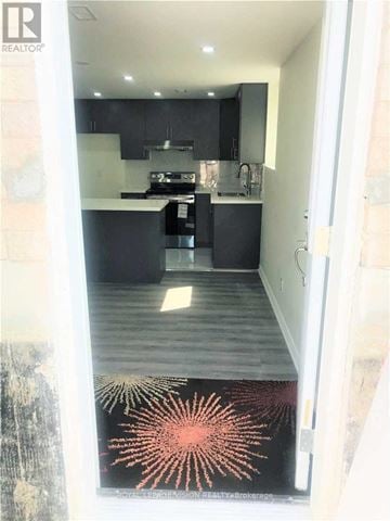 Whitby (Rolling Acres) apartment for rent - A modern kitchen with black cabinets and a wooden floor.