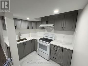 Pickering (Brock Ridge) apartment for rent - A kitchen with a white stove top oven and a white sink.