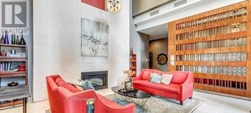 Toronto (Bayview Village) condo for rent - A living room with a red couch and a fireplace.