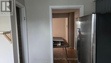 Oshawa (Samac) townhouse for rent - A kitchen with a refrigerator and a table with a notepad and pen on it.