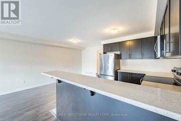Guelph (Grange Road) townhouse for rent - A modern kitchen with a stainless steel refrigerator and black cabinets.
