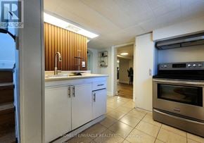 Hamilton (Homeside) apartment for rent - A kitchen with white cabinets and a wooden wall.