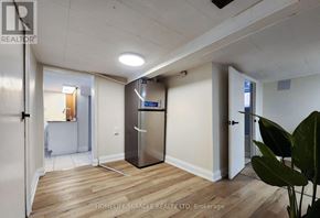 Hamilton (Homeside) apartment for rent - A kitchen area with a refrigerator, a sink, and a door leading to another room.