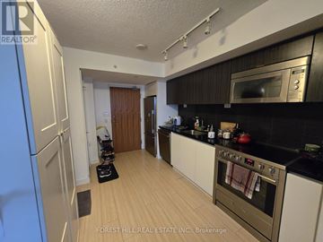 Toronto (Waterfront Communities) condo for rent - A kitchen with a stove top oven and a microwave above it.