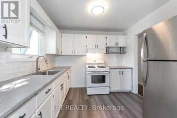 Guelph (Victoria North) apartment for rent - A modern kitchen with white cabinets and stainless steel appliances.