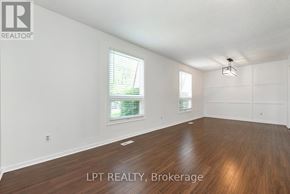 Guelph (Victoria North) apartment for rent - A spacious room with wooden flooring and white walls.