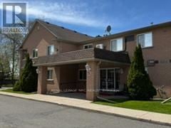 Welland (Prince Charles) condo for rent - A house with a brown roof and a white fence is shown.