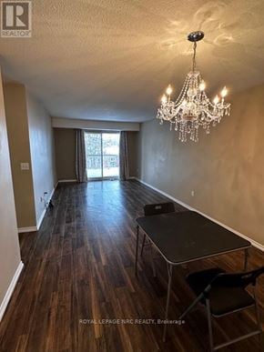 Welland (Prince Charles) condo for rent - A room with a chandelier, a table and chairs, and a window with curtains.