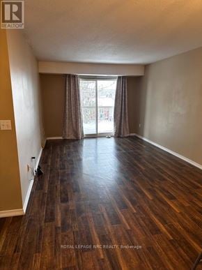 Welland (Prince Charles) condo for rent - A room with wooden flooring and a window with curtains.