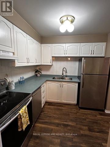 Welland (Prince Charles) condo for rent - A kitchen with white cabinets and a black stove top.