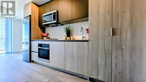 Toronto (Newtonbrook West) condo for rent - A modern kitchen with wooden cabinets and a stainless steel refrigerator.