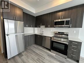 Pickering (Bay Ridges) condo for rent - A modern kitchen with a refrigerator, oven, microwave, and cabinets.