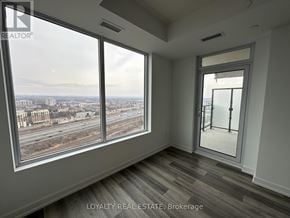 Pickering (Bay Ridges) condo for rent - A room with a view of a highway and buildings outside the window.