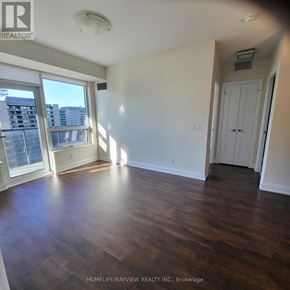 Toronto (Willowdale East) condo for rent - A room with wooden floors and a large window.