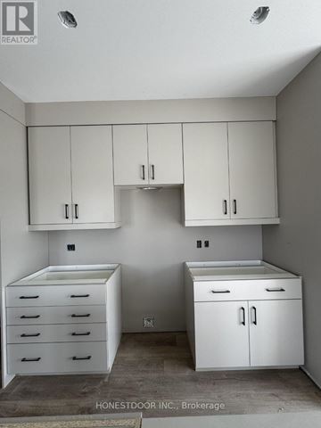 South Bruce apartment for rent - A white kitchen with a refrigerator, sink, and cabinets.