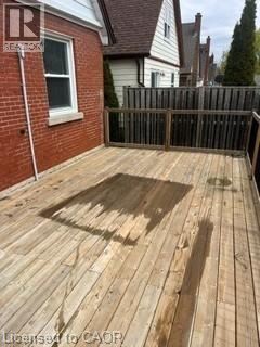 Kitchener apartment for rent - A wooden deck with a fence and a house in the background.