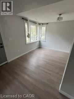 Kitchener apartment for rent - A room with wooden flooring and a window with curtains.