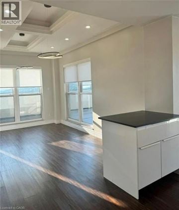 Hamilton condo for rent - A spacious kitchen with white cabinets and a black countertop.