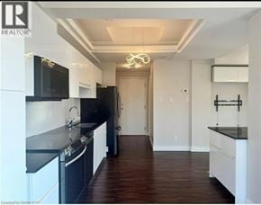 Hamilton condo for rent - A modern kitchen with black countertops and white cabinets.