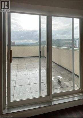 Hamilton condo for rent - A view from a window of a balcony with a glass door.