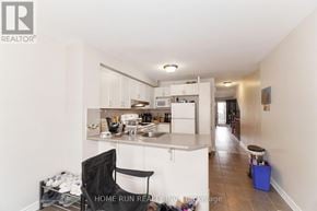 Ottawa townhouse for rent - A kitchen with a black chair and a blue bin on the floor.