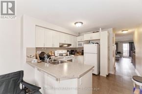 Ottawa townhouse for rent - A kitchen with a sink, refrigerator, and cabinets.