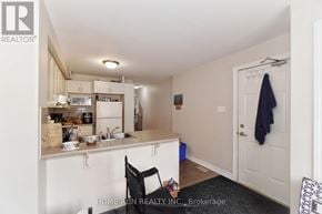 Ottawa townhouse for rent - A kitchen with a sink, stove, and cabinets.