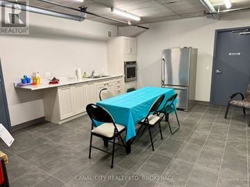 Thorold (Thorold Downtown) apartment for rent - A kitchen area with a table covered in a blue tablecloth and chairs around it.