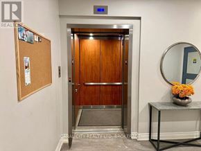 Thorold (Thorold Downtown) apartment for rent - A wooden door with a mirror and a flower vase on a table.