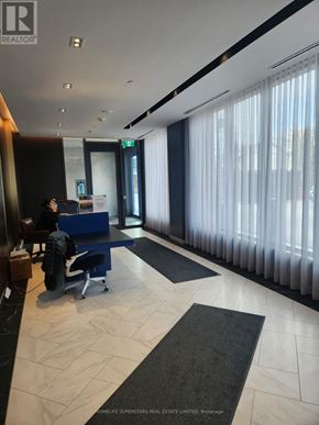 Toronto (Annex) condo for rent - A room with a blue chair and a desk with a computer on it.