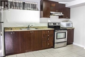 Toronto (Parkwoods-Donalda) duplex for rent - A kitchen with brown cabinets and a granite countertop.