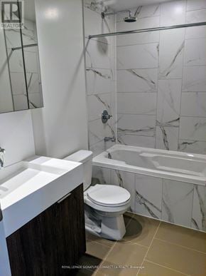 Toronto (Waterfront Communities) condo for rent - A white toilet sits in a marble bathroom.