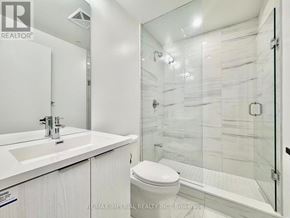 Vaughan (Vaughan Corporate Centre) condo for rent - A white bathroom with a glass shower stall and a toilet.